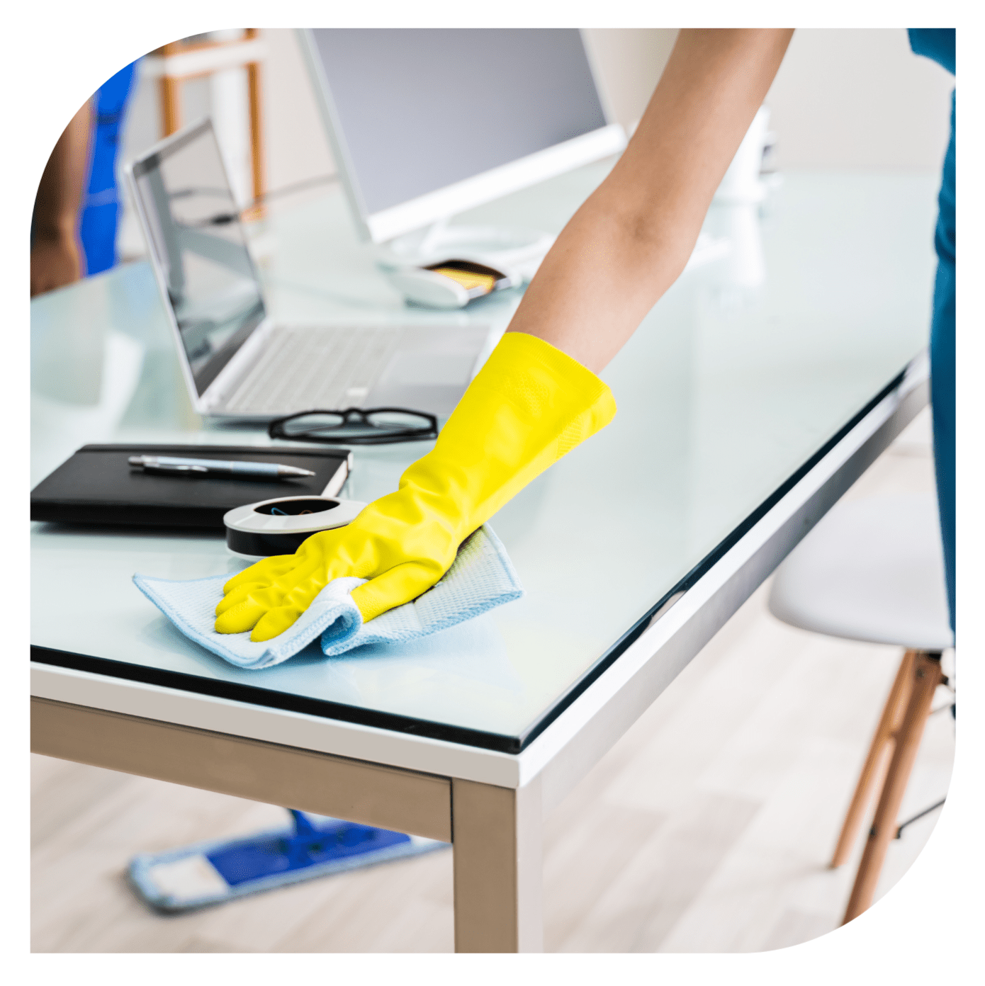 Person cleaning desk with yellow gloves.